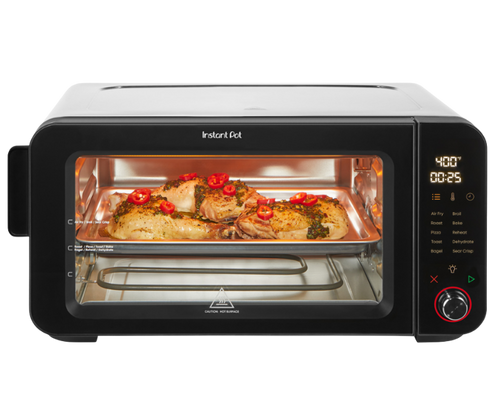Front-facing view of the Instant Pot 6-Slice InstantHeat Air Fryer Toaster Oven with the door closed. A tray of seasoned chicken and vegetables is visible through the glass window. The digital display shows 400°F and 25 minutes. Touchscreen panel with cooking presets and control knob is on the right.