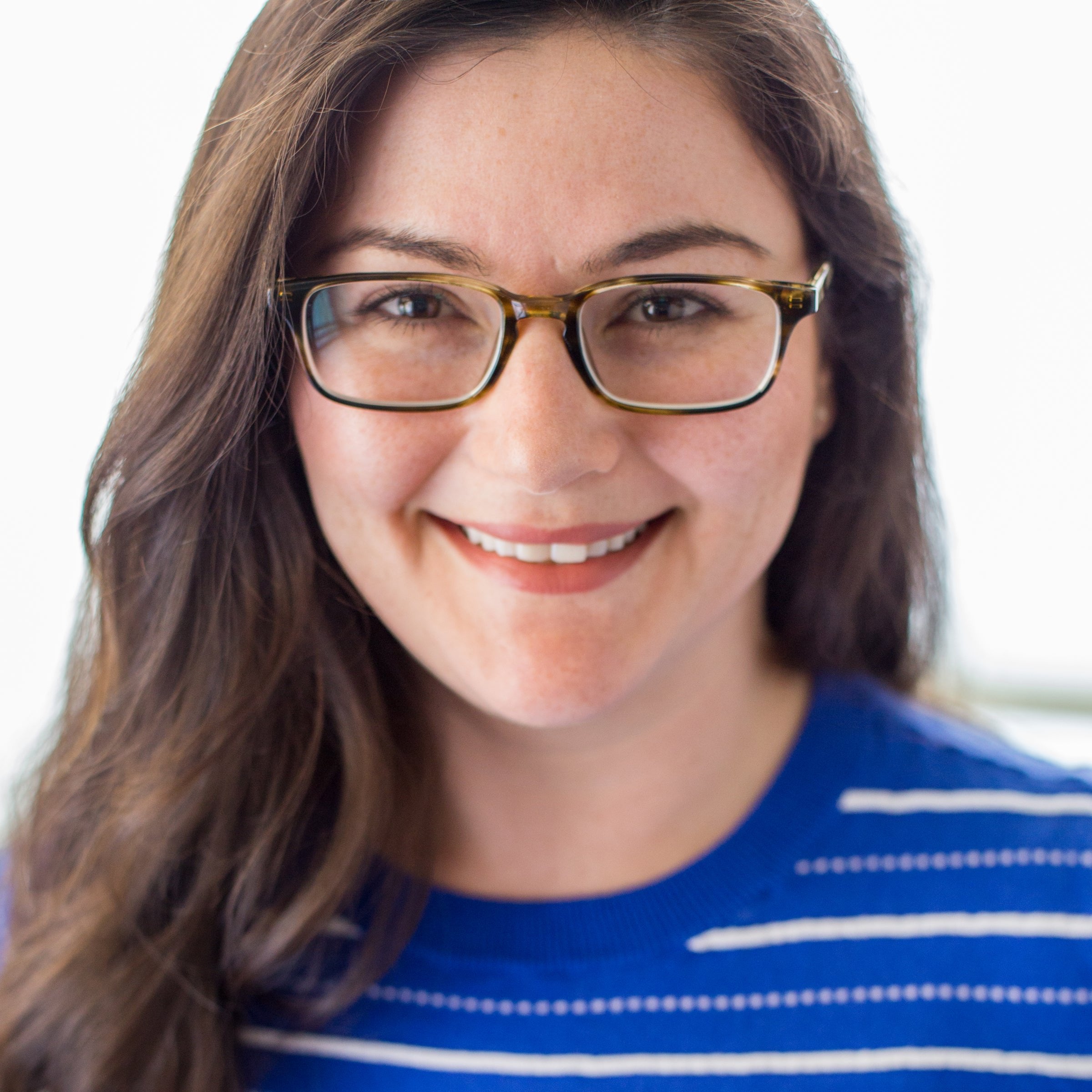 Coco Morante, one of Instant Pot's cooking collaborators, smiling in a bright, natural light setting. She wears glasses and a blue striped sweater.