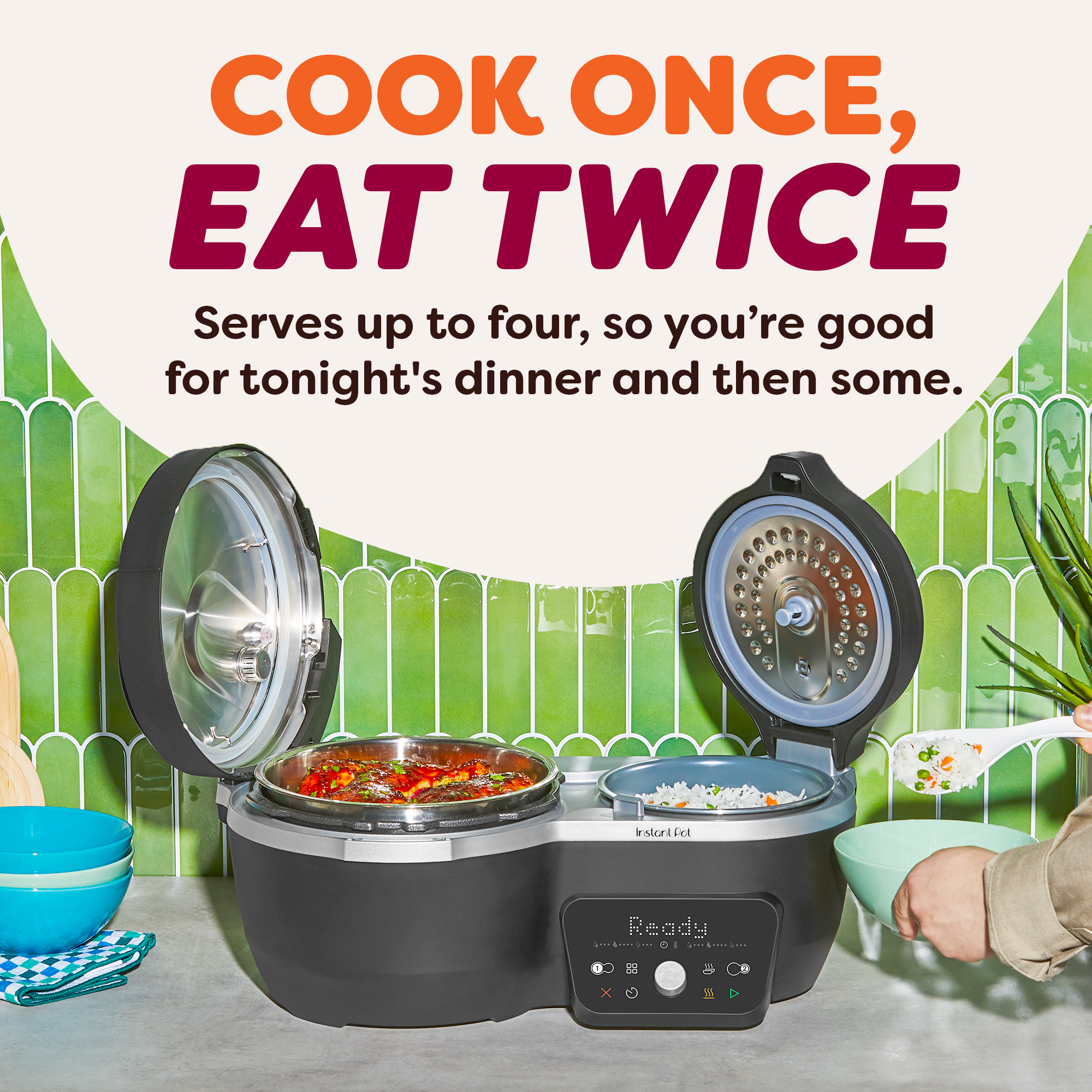Black Dual Action Multi-Cooker with both lids open, revealing a larger main pot with glazed chicken and a smaller side pot with vegetable rice. Info shows that product serves up to four people.
