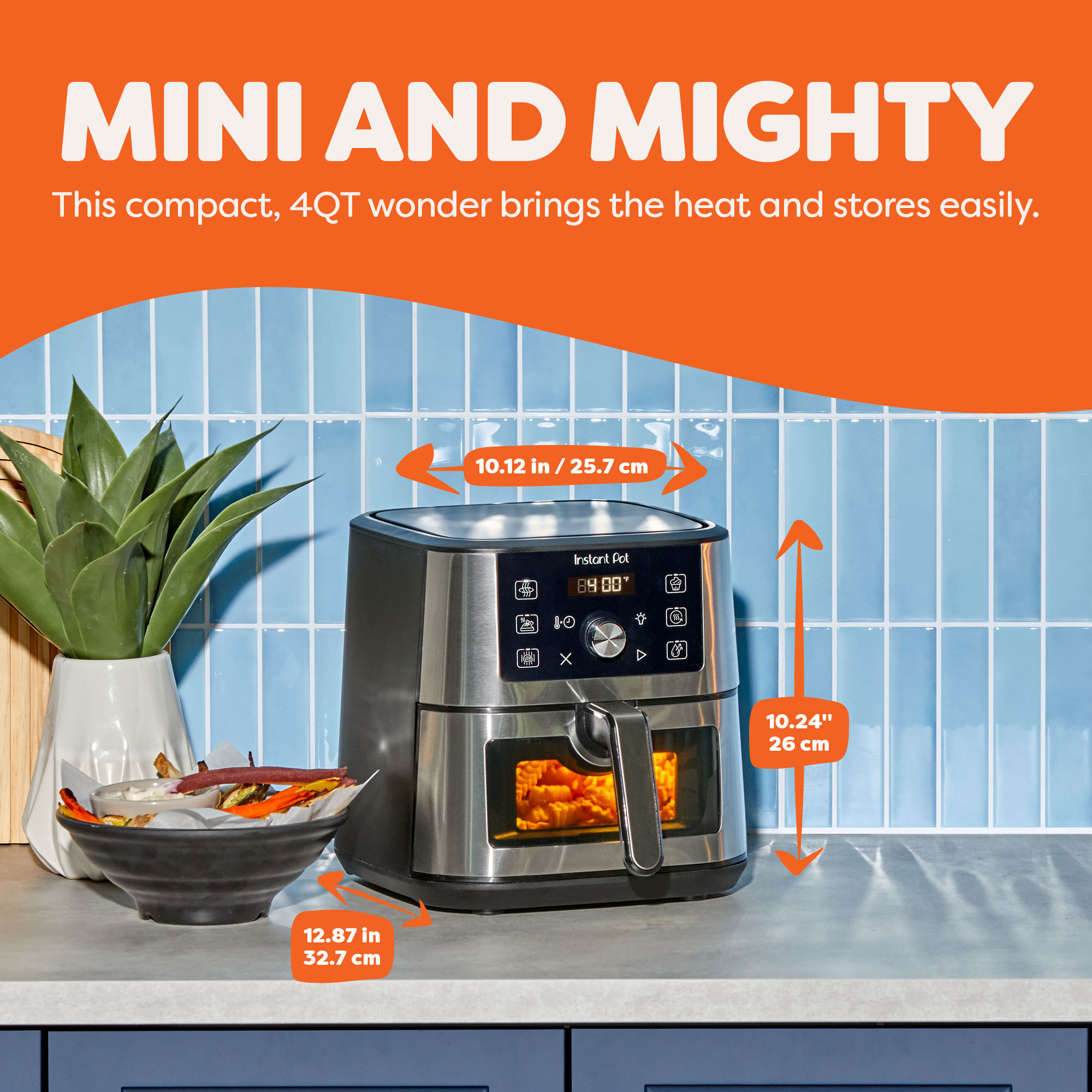 Instant Pot® 4QT VORTEX® Mini Air Fryer in Stainless Steel on a kitchen counter, with dimensions labeled: 10.12 inches wide, 10.24 inches tall, and 12.87 inches deep. The appliance displays 400°F and has fries cooking inside, next to a bowl of sweet potato fries and a potted plant, with the headline “Mini and Mighty.”