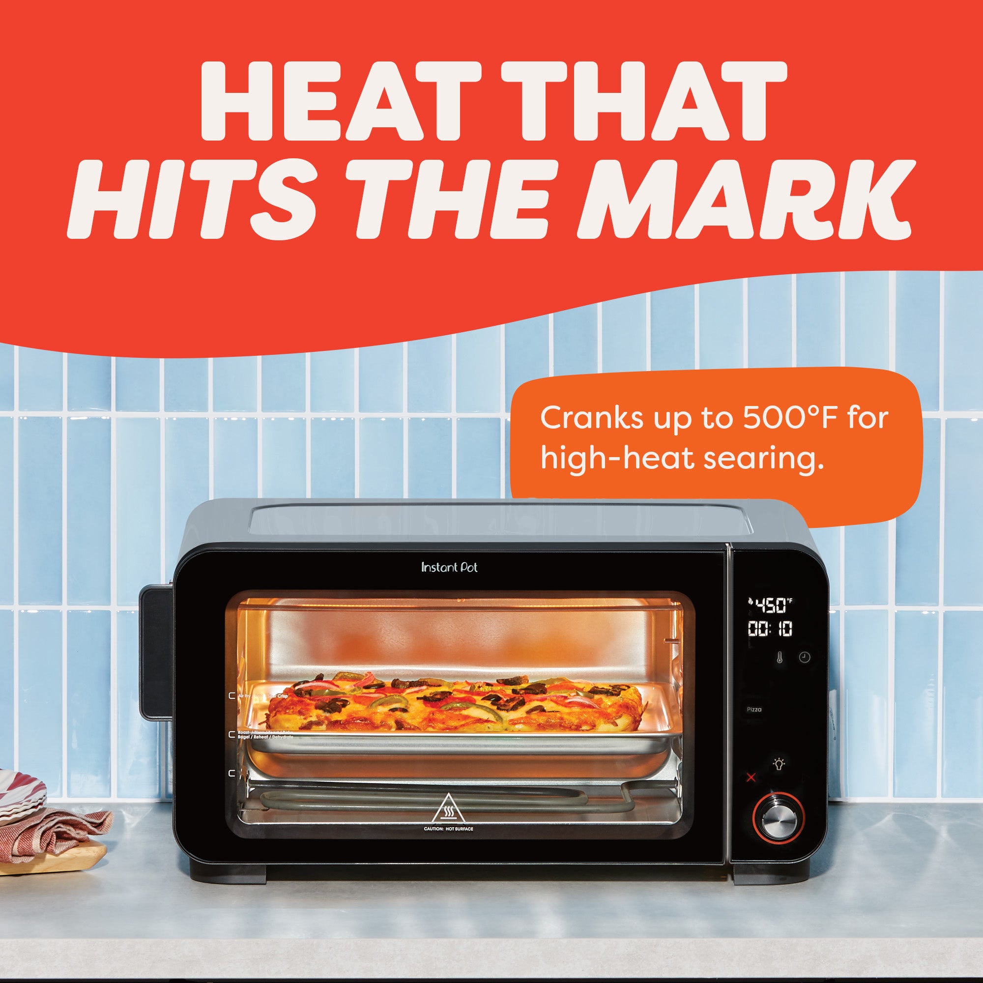 Pizza bakes inside the Instant Pot® 6-Slice InstantHeat™ Air Fryer Toaster Oven, with a display showing 450°F. Text reads “Heat That Hits the Mark,” noting the appliance can reach up to 500°F for high-heat searing.
