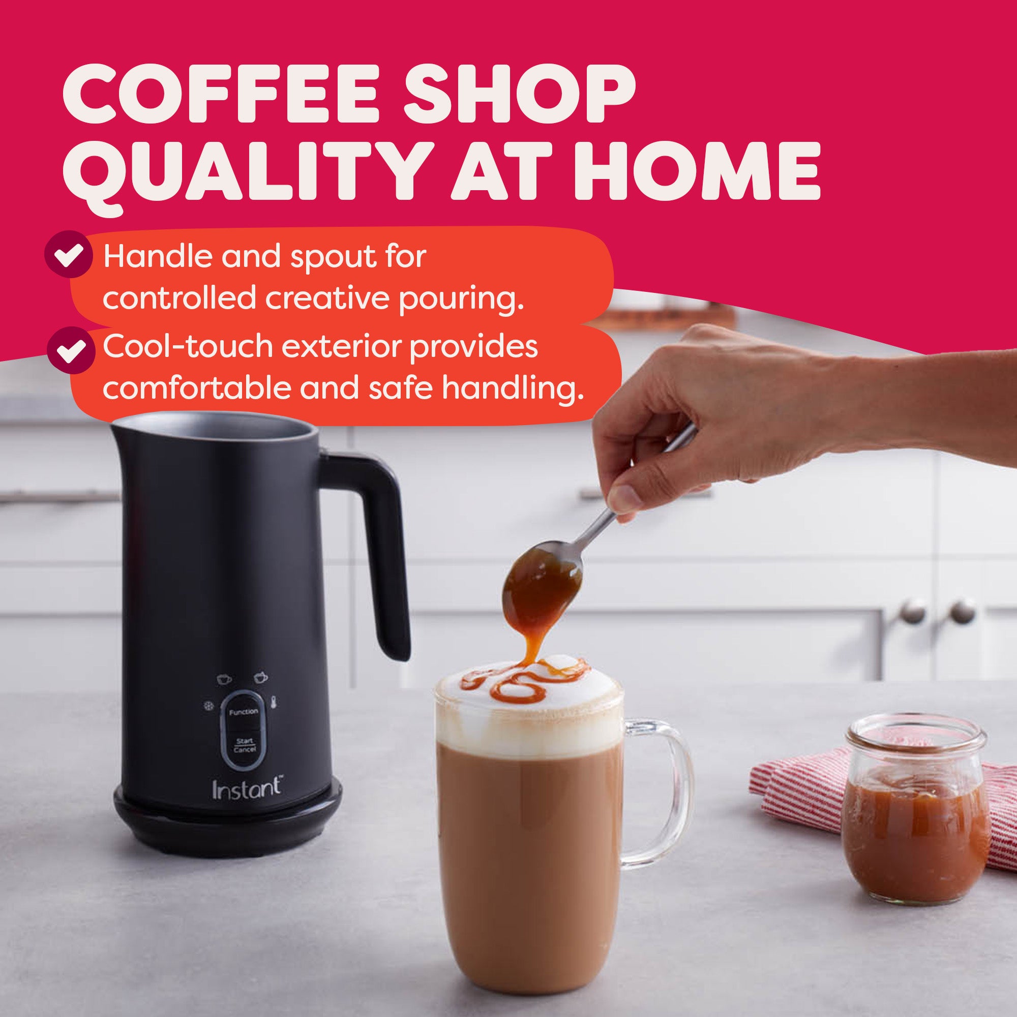Instant milk frother on a kitchen counter with text reading: 'Coffee shop quality at home — Handle and spout for controlled creative pouring. Cool-touch exterior provides comfortable and safe handling.' A hand drizzles caramel sauce from a spoon onto a foamy latte in a glass mug, with a jar of caramel nearby.