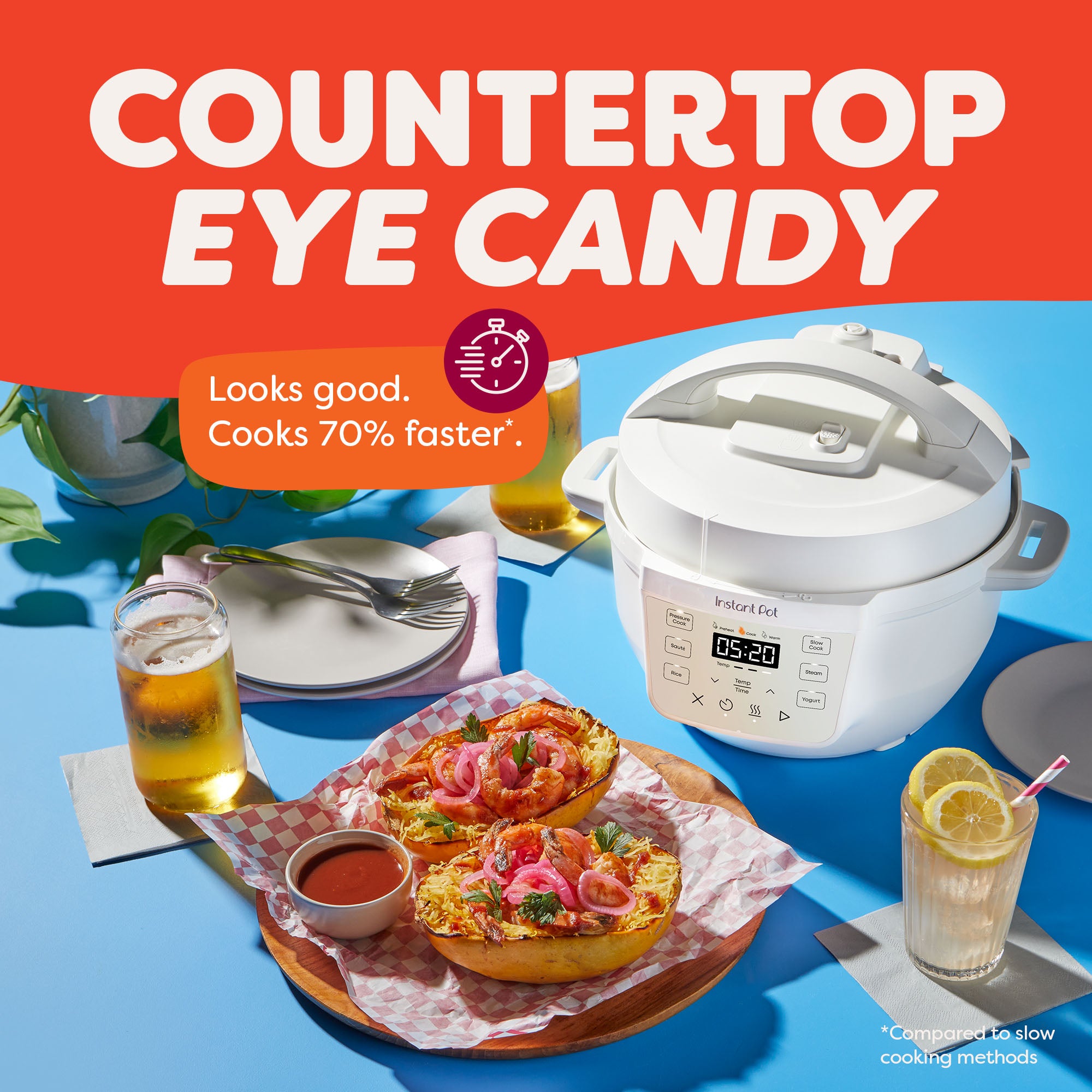 Instant Pot® 4QT RIO™ Mini Multi-Cooker in Sea Salt displayed on a pink tiled countertop surrounded by drinks, plates, and a tray of stuffed sweet potatoes with chickpeas and greens. A callout reads, “Looks good. Cooks 70% faster*,” and the bold header above states, “Countertop Eye Candy.” A small footnote clarifies: “*Compared to slow cooking methods.”