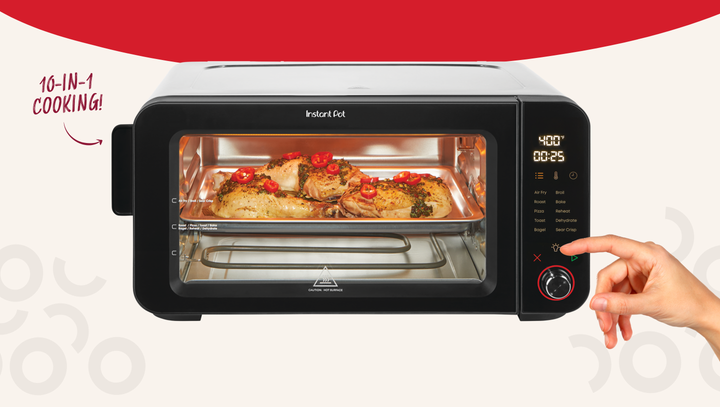 An Instant Pot 6-Slice InstantHeat Air Fryer Toaster Oven with food roasting inside on a baking tray. The digital display on the right shows a temperature of 400°F and a timer set to 25 minutes. A hand is adjusting the control knob. To the left of the oven, bold red text reads “10-IN-1 COOKING!” with an arrow pointing toward the appliance.